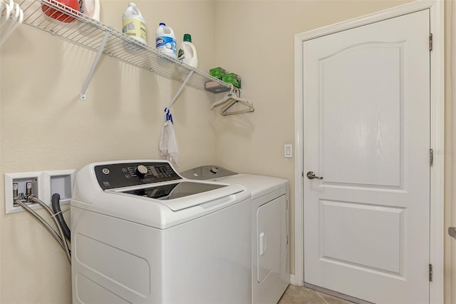 laundry room featuring washer and dryer and light tile patterned flooring