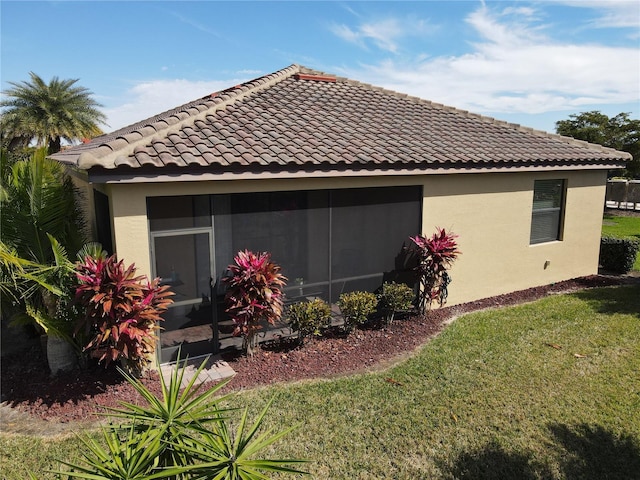 view of home's exterior featuring a lawn and a sunroom