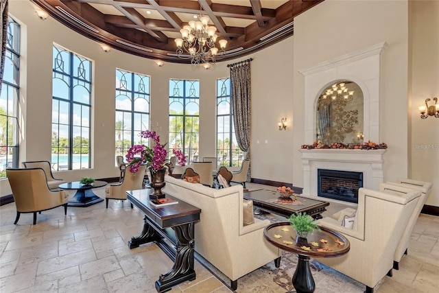 living room with beam ceiling, coffered ceiling, a high ceiling, a notable chandelier, and crown molding