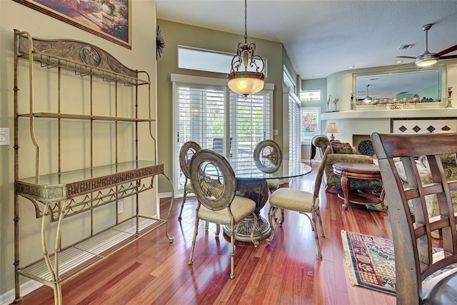 dining area featuring a textured ceiling, ceiling fan, and hardwood / wood-style flooring