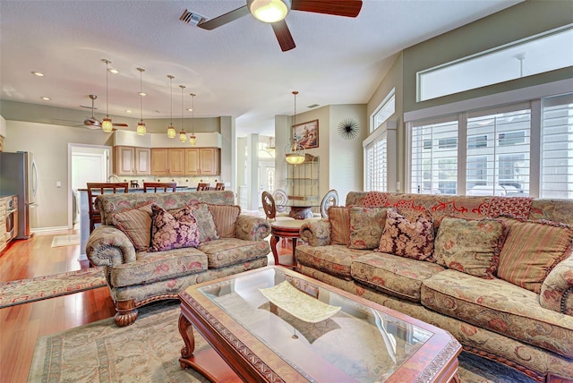 living room with ceiling fan and light hardwood / wood-style flooring