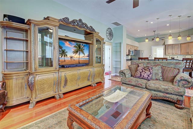 living room featuring light hardwood / wood-style floors and ceiling fan