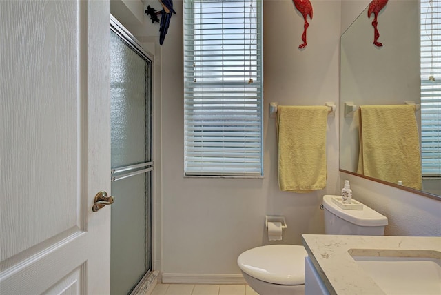 bathroom featuring a healthy amount of sunlight, tile floors, toilet, and vanity