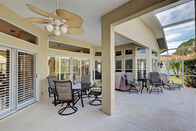 view of patio featuring ceiling fan, grilling area, and a lanai