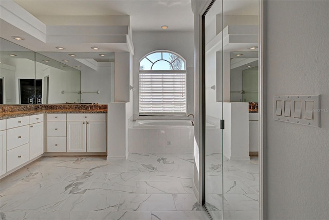 bathroom featuring a raised ceiling, tile floors, vanity, and a bath to relax in