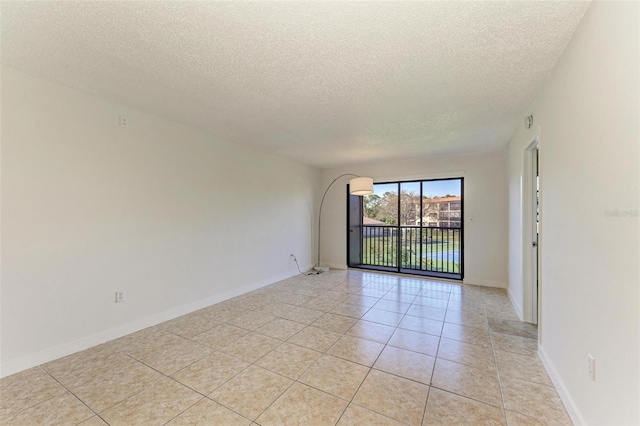 spare room featuring a textured ceiling and light tile floors