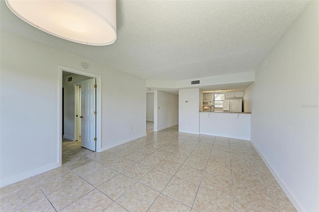 unfurnished room featuring light tile floors and a textured ceiling