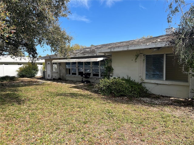 rear view of property with a lawn