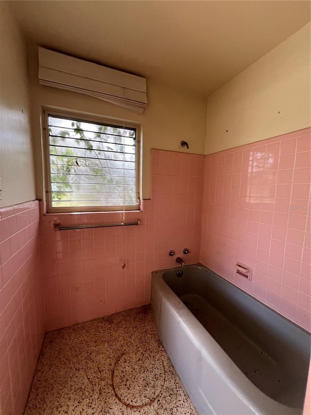 bathroom featuring tile walls, shower / washtub combination, and a wall unit AC