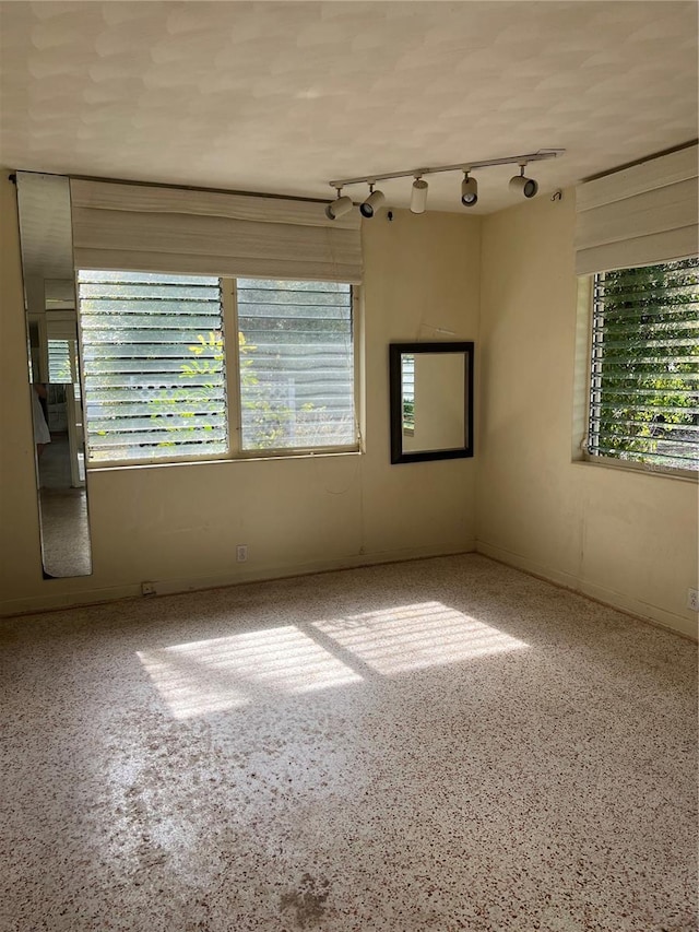 unfurnished room featuring track lighting