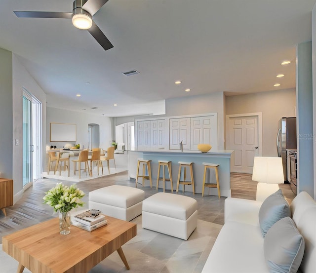 tiled living room with ceiling fan