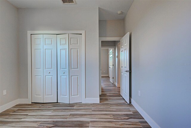 unfurnished bedroom featuring a closet and light wood-type flooring