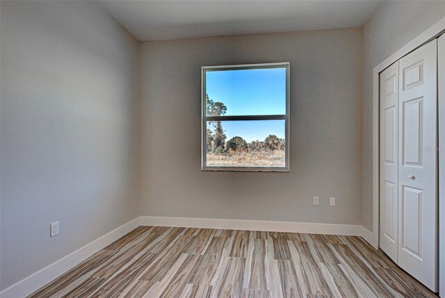 unfurnished bedroom featuring a closet and light wood-type flooring