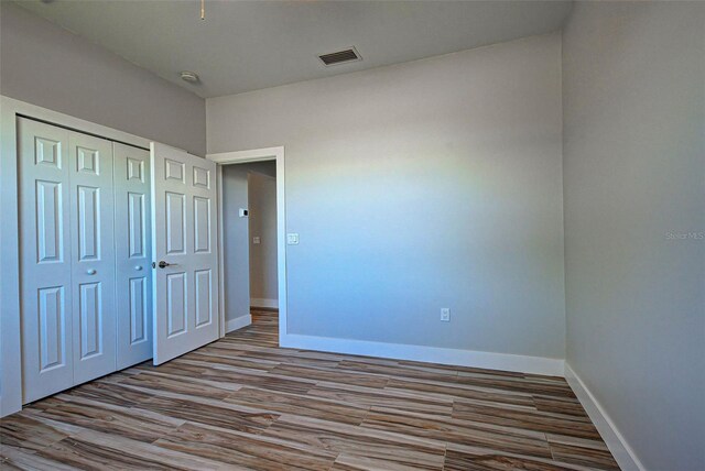 unfurnished bedroom featuring a closet and dark hardwood / wood-style flooring