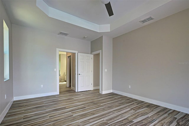 unfurnished room with a raised ceiling and ceiling fan