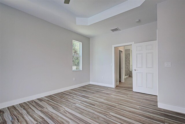 empty room with ceiling fan and light hardwood / wood-style flooring