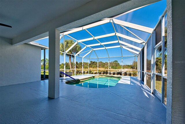 view of swimming pool with a patio area and glass enclosure