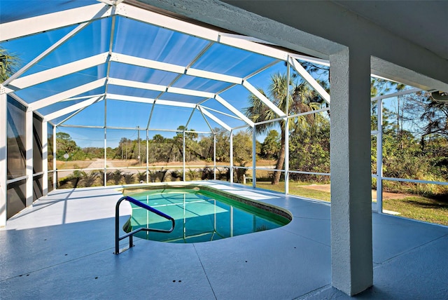 view of pool featuring glass enclosure and a patio area