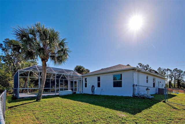 rear view of property with a yard and a lanai