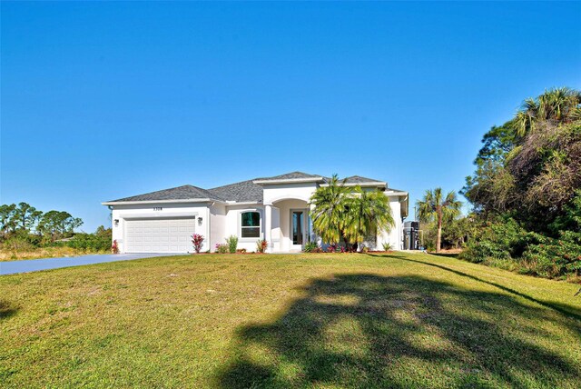 view of front of property featuring a front lawn and a garage