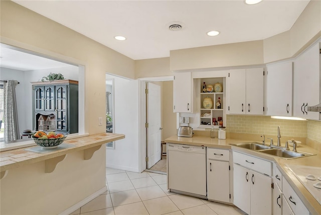 kitchen with white appliances, white cabinets, light tile floors, and sink