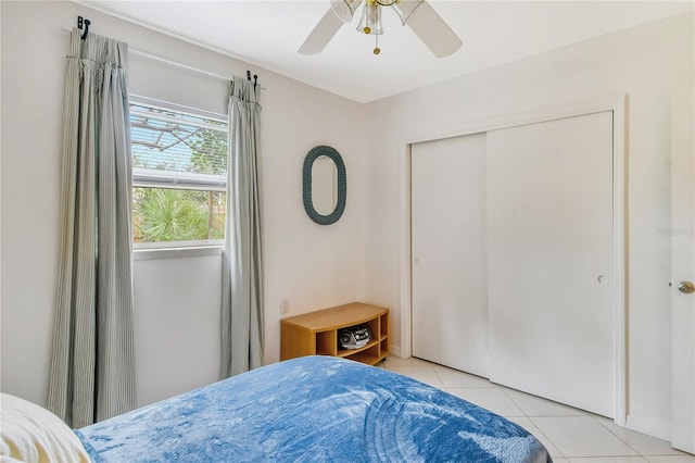 bedroom featuring a closet, ceiling fan, and light tile floors