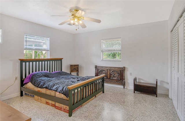 bedroom featuring a closet, multiple windows, and ceiling fan