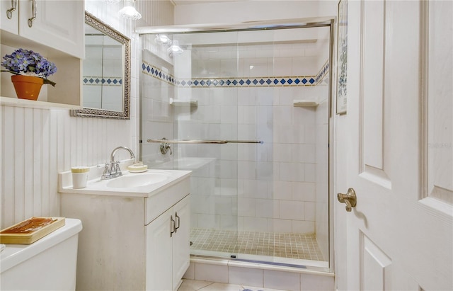 bathroom featuring toilet, large vanity, walk in shower, and tile flooring