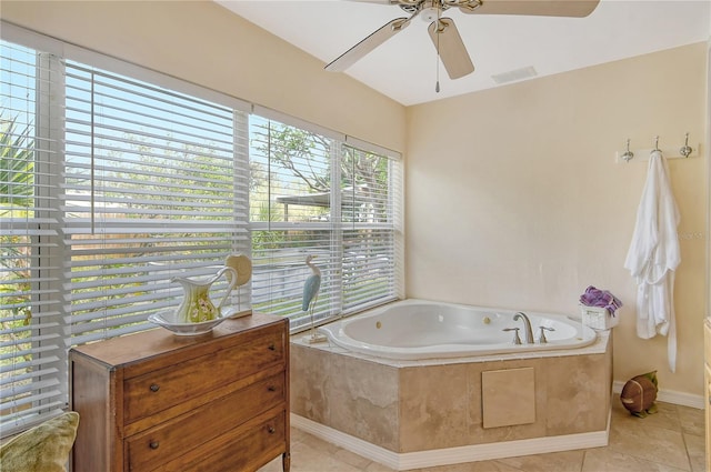 bathroom with tiled tub, ceiling fan, and tile flooring