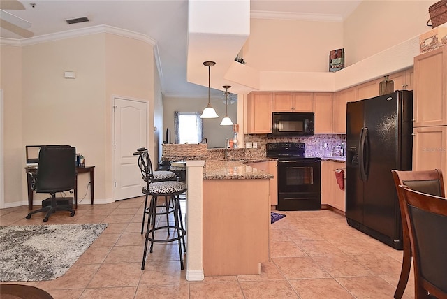 kitchen with kitchen peninsula, light stone counters, light tile flooring, black appliances, and a kitchen bar