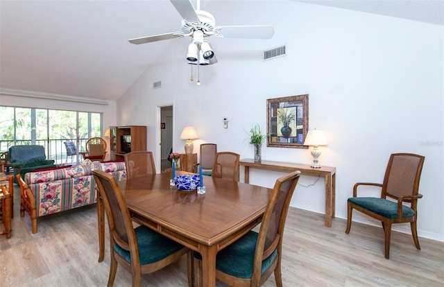 dining space with light hardwood / wood-style flooring, ceiling fan, and high vaulted ceiling