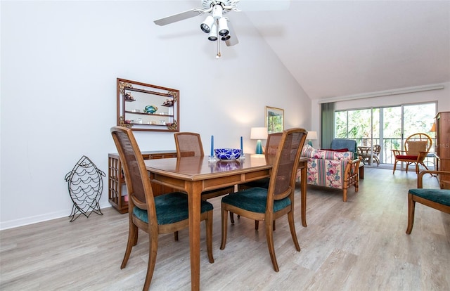 dining room with high vaulted ceiling, light hardwood / wood-style floors, and ceiling fan