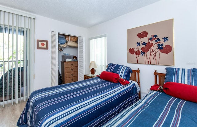 bedroom featuring a textured ceiling, a closet, and light hardwood / wood-style flooring