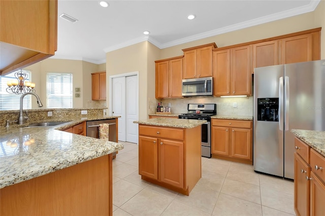 kitchen featuring stainless steel appliances, a kitchen island, sink, and light stone counters