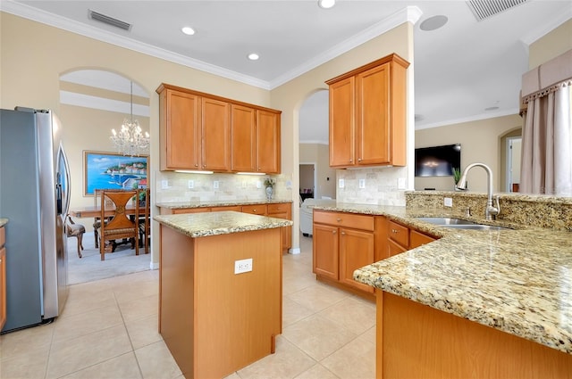 kitchen featuring stainless steel refrigerator with ice dispenser, kitchen peninsula, sink, and light stone countertops