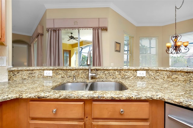 kitchen featuring light stone counters, crown molding, sink, and pendant lighting