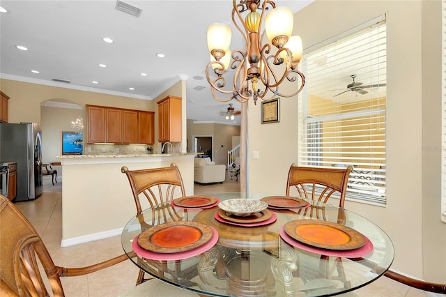 dining room with crown molding, ceiling fan with notable chandelier, and light tile patterned floors