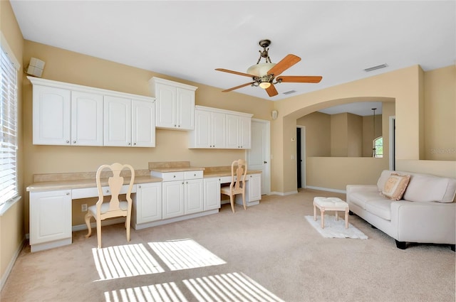 interior space featuring built in desk and ceiling fan