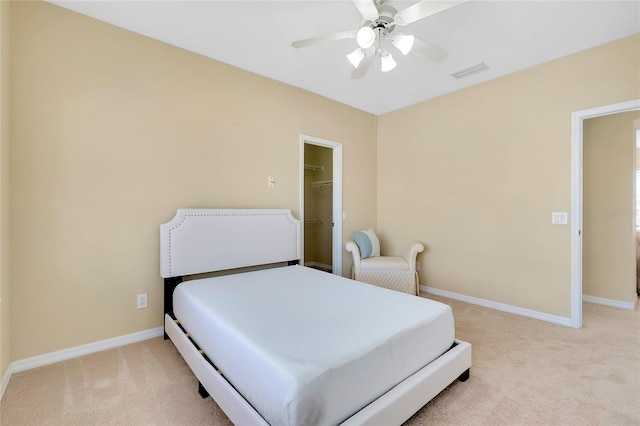 carpeted bedroom featuring a walk in closet, ceiling fan, and a closet