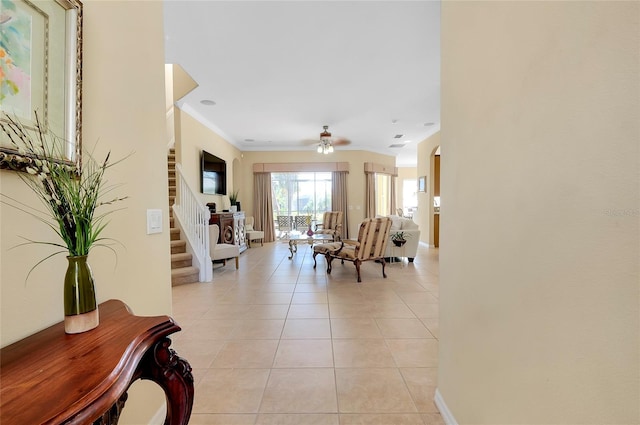 interior space with ornamental molding and ceiling fan