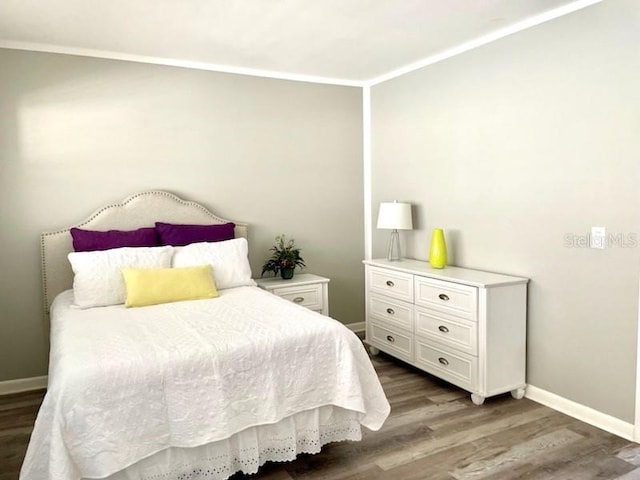 bedroom with ornamental molding and wood-type flooring