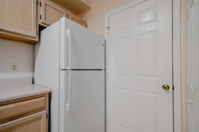 kitchen featuring light brown cabinetry and white refrigerator