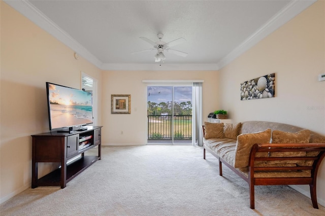 sitting room with plenty of natural light, crown molding, light colored carpet, and ceiling fan