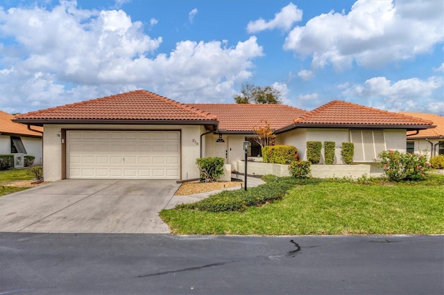 mediterranean / spanish house featuring a garage and a front lawn