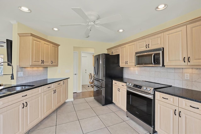 kitchen featuring ceiling fan, tasteful backsplash, light tile patterned flooring, and stainless steel appliances