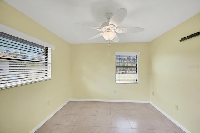 empty room featuring light tile patterned floors, baseboards, and a ceiling fan