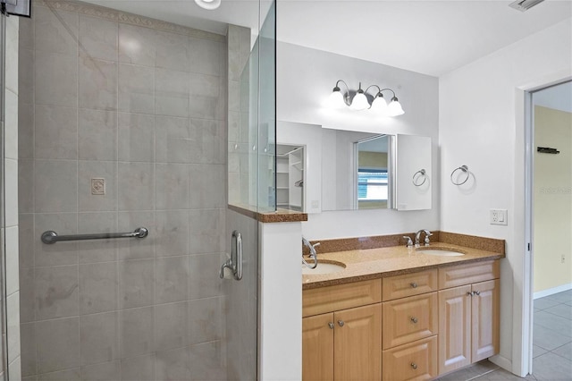 full bathroom featuring double vanity, a sink, a shower stall, and tile patterned floors