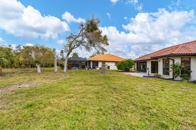 view of yard with a lanai and a patio area