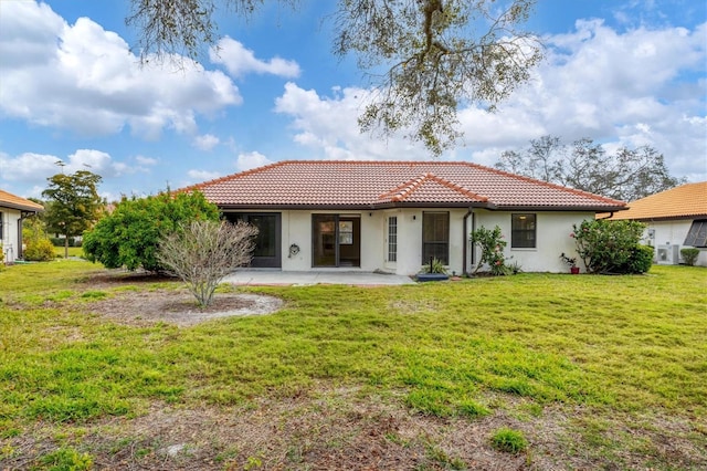 mediterranean / spanish home with a patio area, a tile roof, a front lawn, and stucco siding