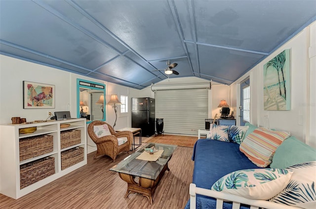 living room featuring light wood-type flooring and vaulted ceiling